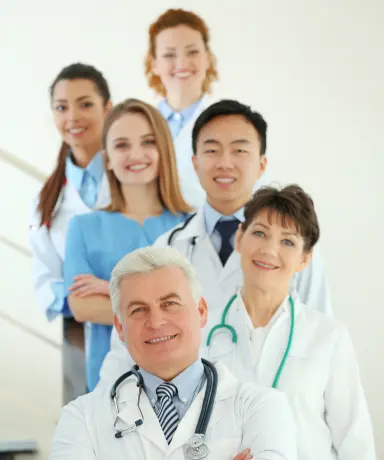 Senior doctor leading diverse medical records review team of medical professionals in white coats at office
