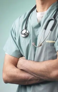 Medical professional in scrubs with stethoscope and arms crossed represents AI Human Legal Transcription Services